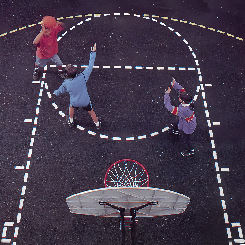 Two young girls playing basketball in a school gymnasium.