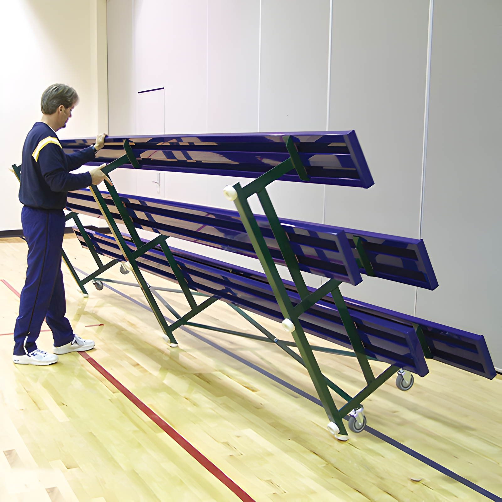 Isometric view of long indoor bleacher seats with blue planks.