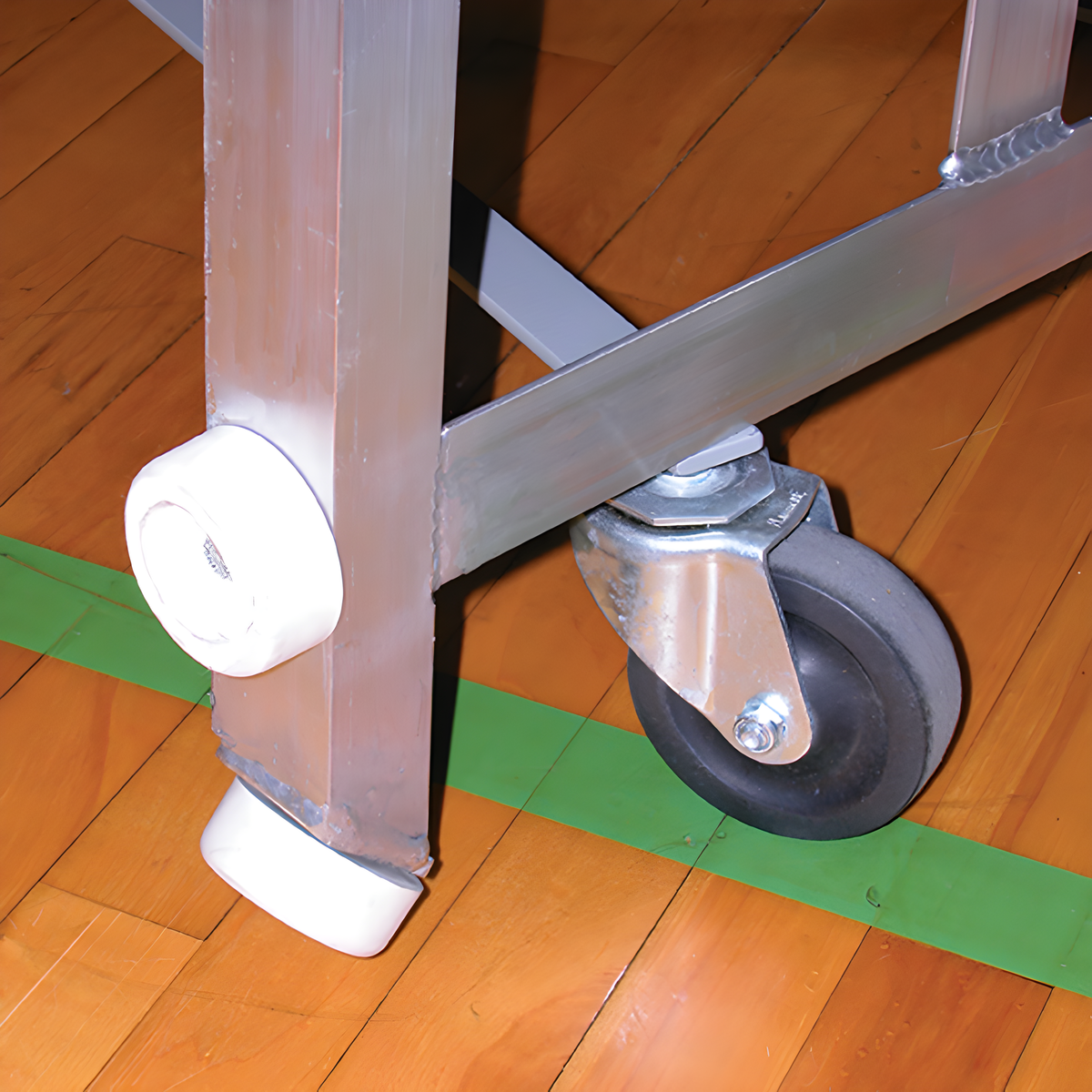 Close-up of indoor bleacher seats&#39; aluminum frame with caster wheels.